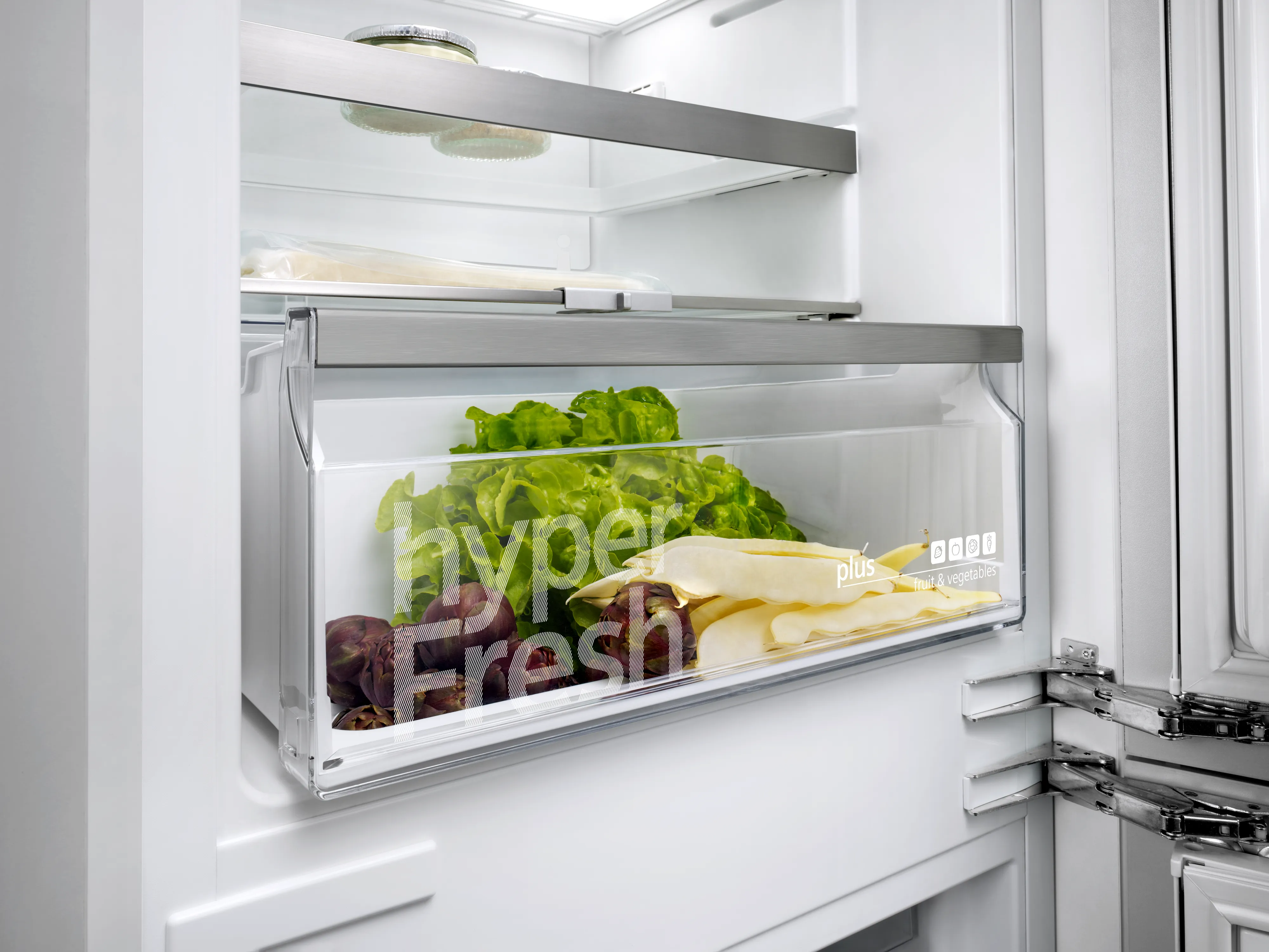 Un réfrigérateur Siemens ouvert avec son tiroir hyperFresh contenant des légumes frais.
