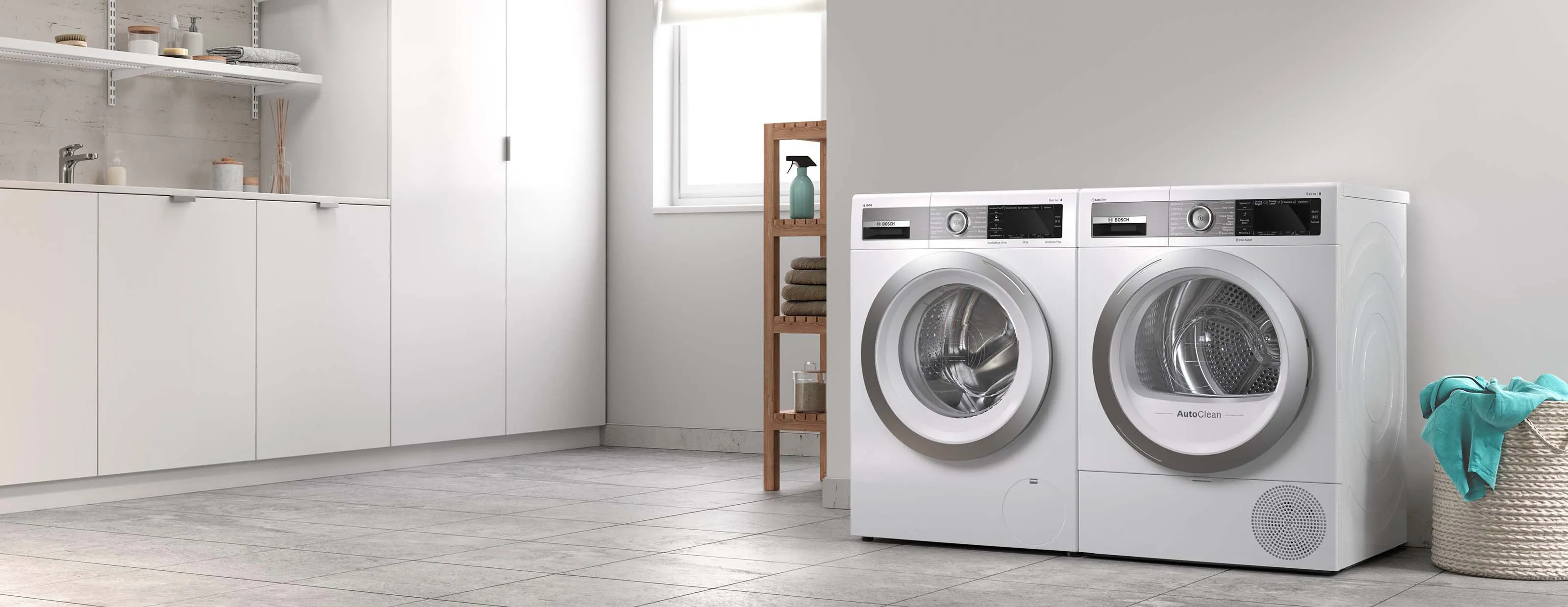 Bosch freestanding washer next to condense dryer in a modern laundry room.