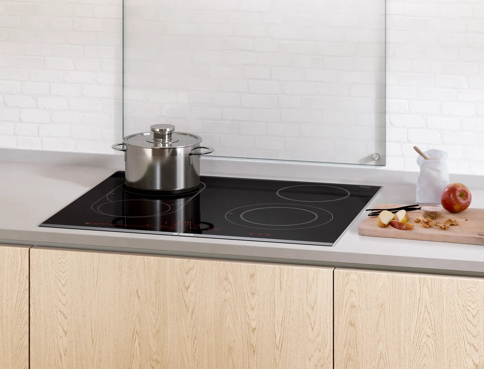 Modern kitchen with induction cooktop, stainless steel pot, and wooden cabinets.
