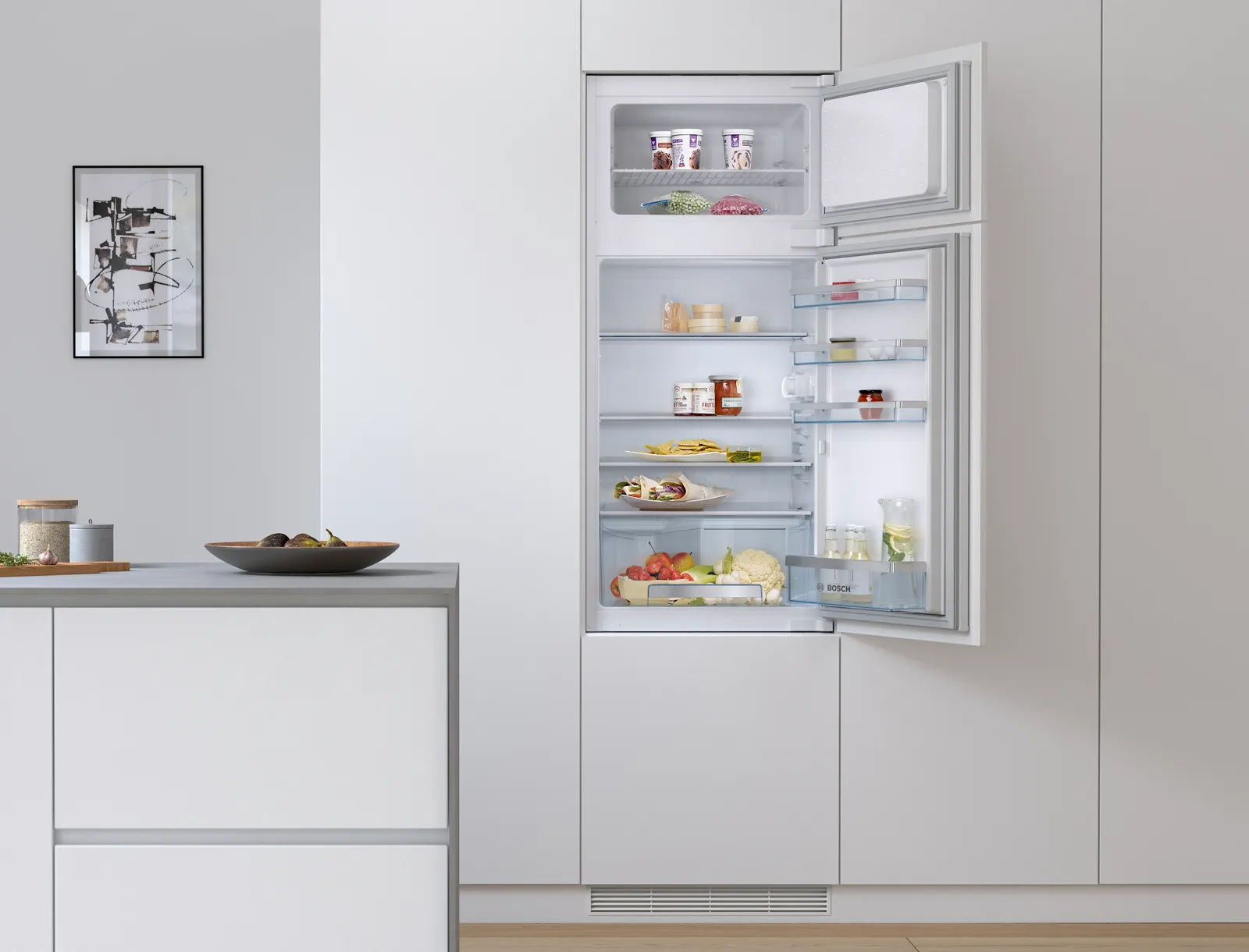 Open refrigerator with various food items and kitchen counter with bowls in modern, minimalist interior.