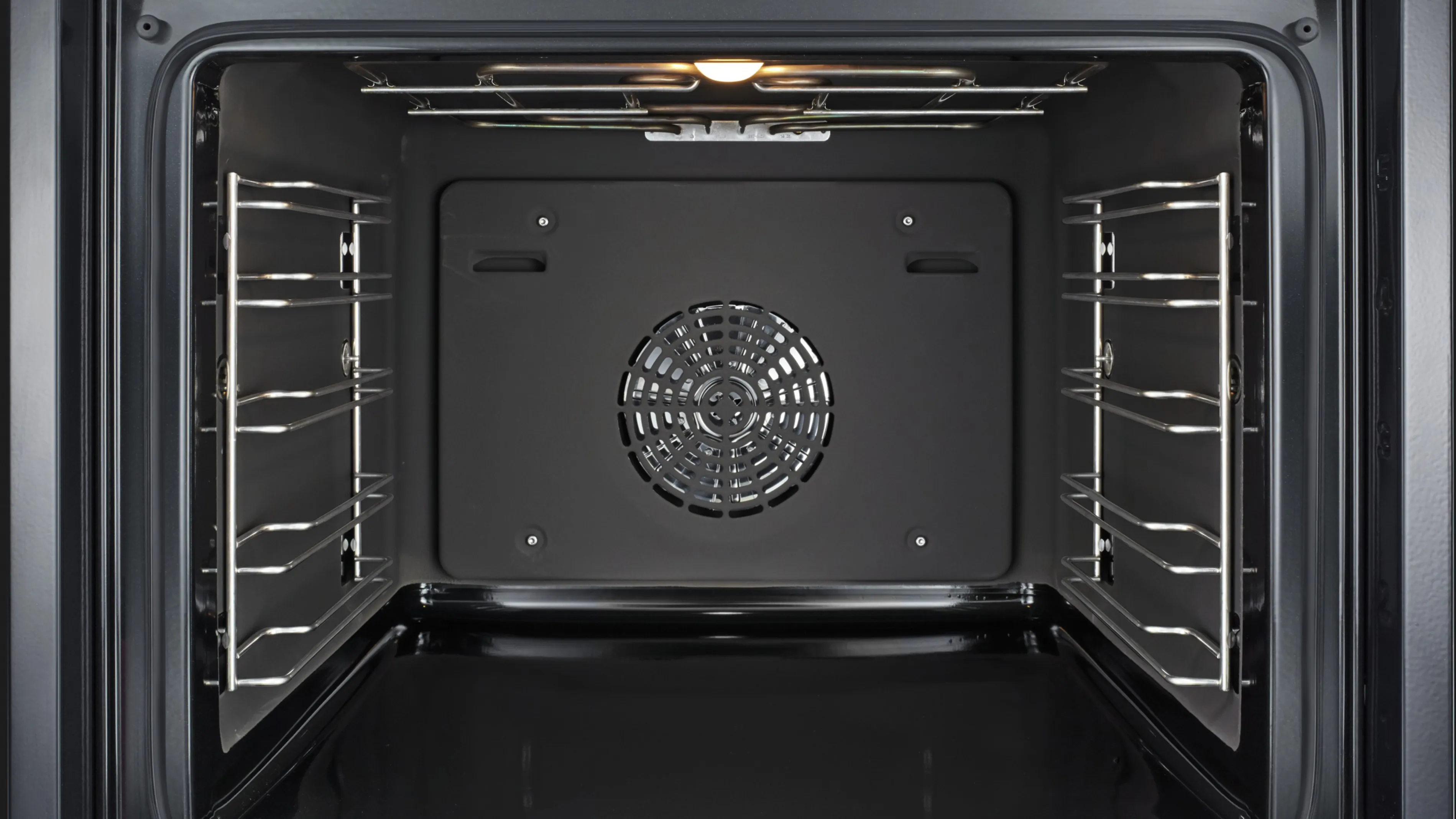 Interiorul cuptorului gol cu ventilator și elemente de încălzire.
