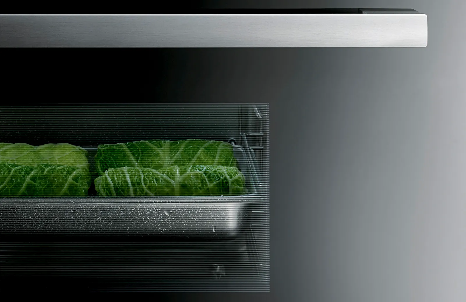 Bosch Serie 8 Einbau-Dampfgarer mit Wirsingkohl im Edelstahl-Garbehälter hinter geriffeltem Sichtfenster.