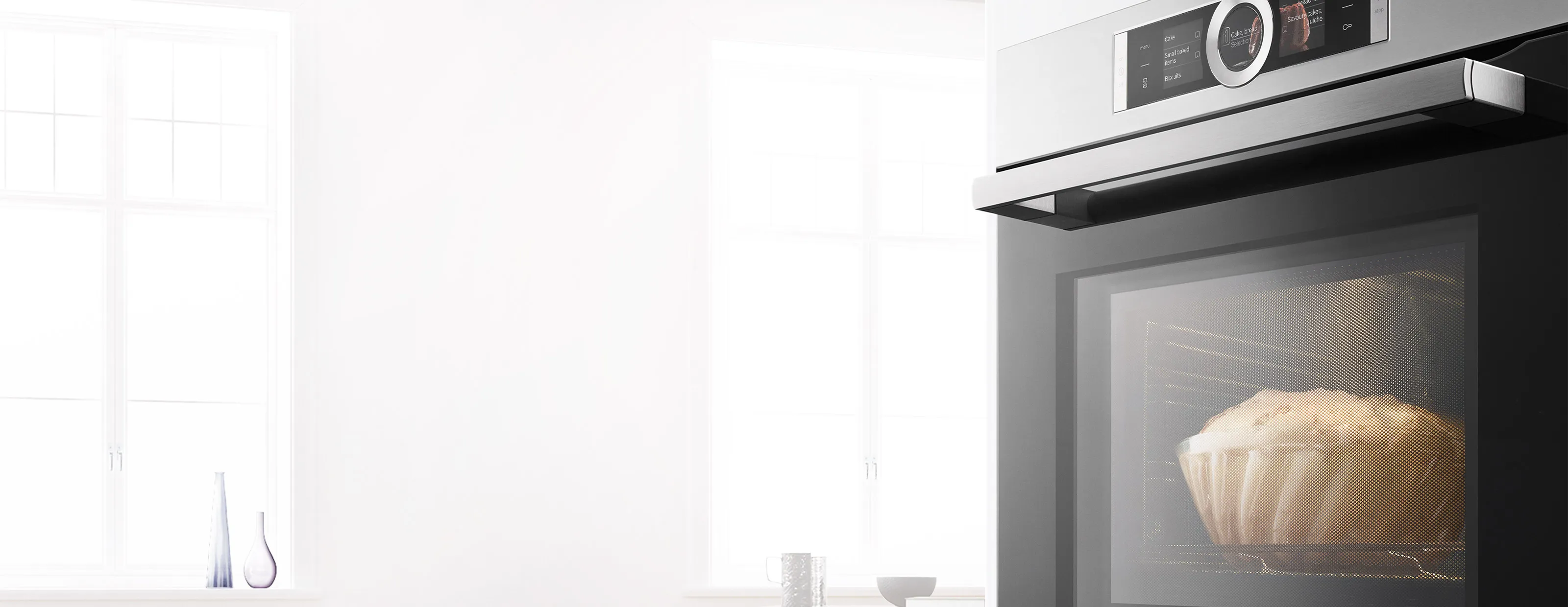 Bosch Serie 8 Einbaubackofen mit digitalem Bedienring und einem fertig gebackenen Gugelhupf im beleuchteten Innenraum.