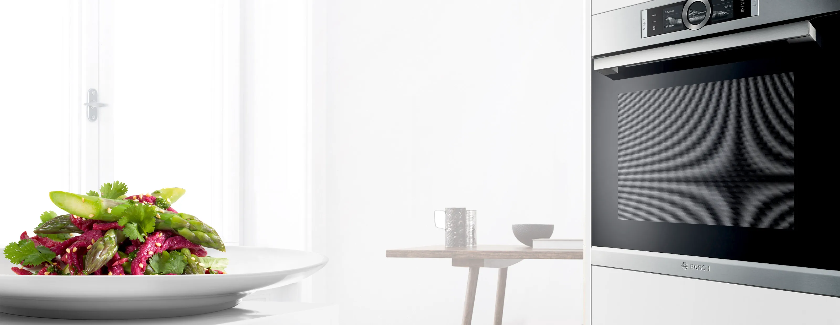Helle Küchenausstattung mit frischem Salat, Küchengeräten und minimalistischem Dekor.