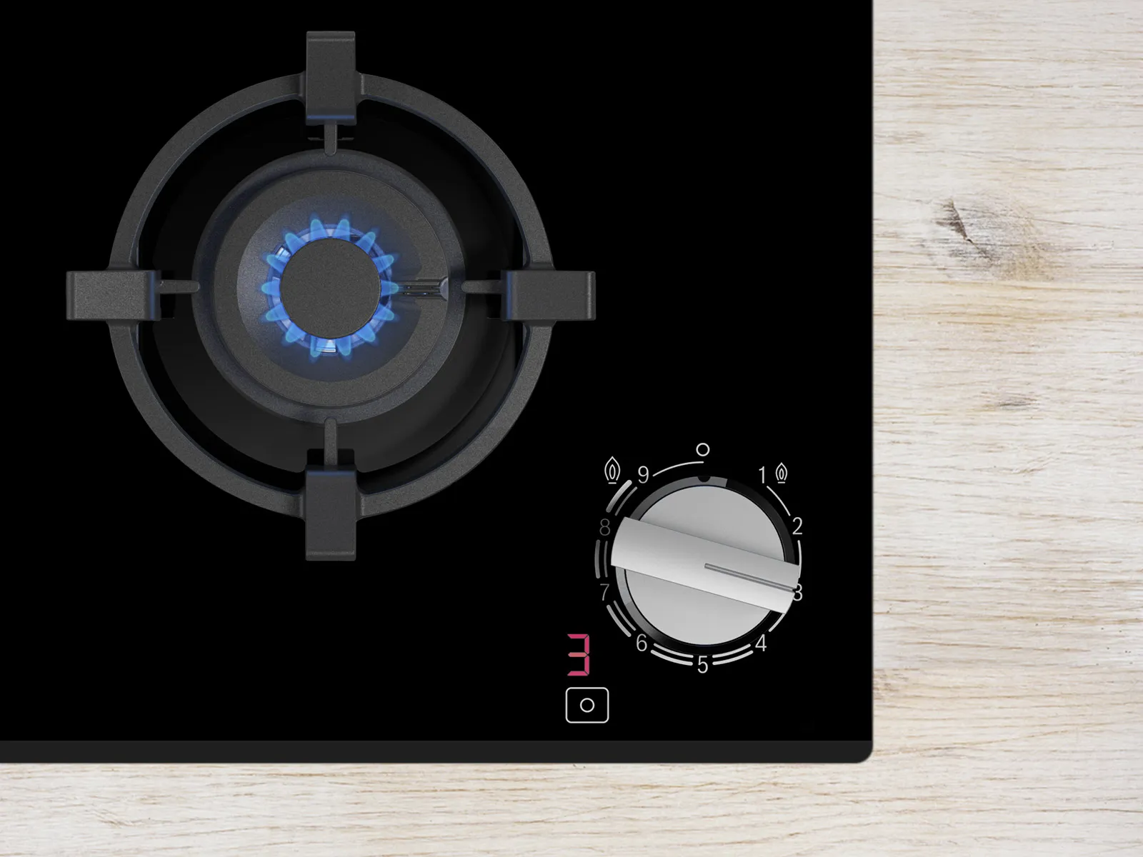 A gas stove with a blue flame and control knob, set against a sleek black surface and light wooden background.