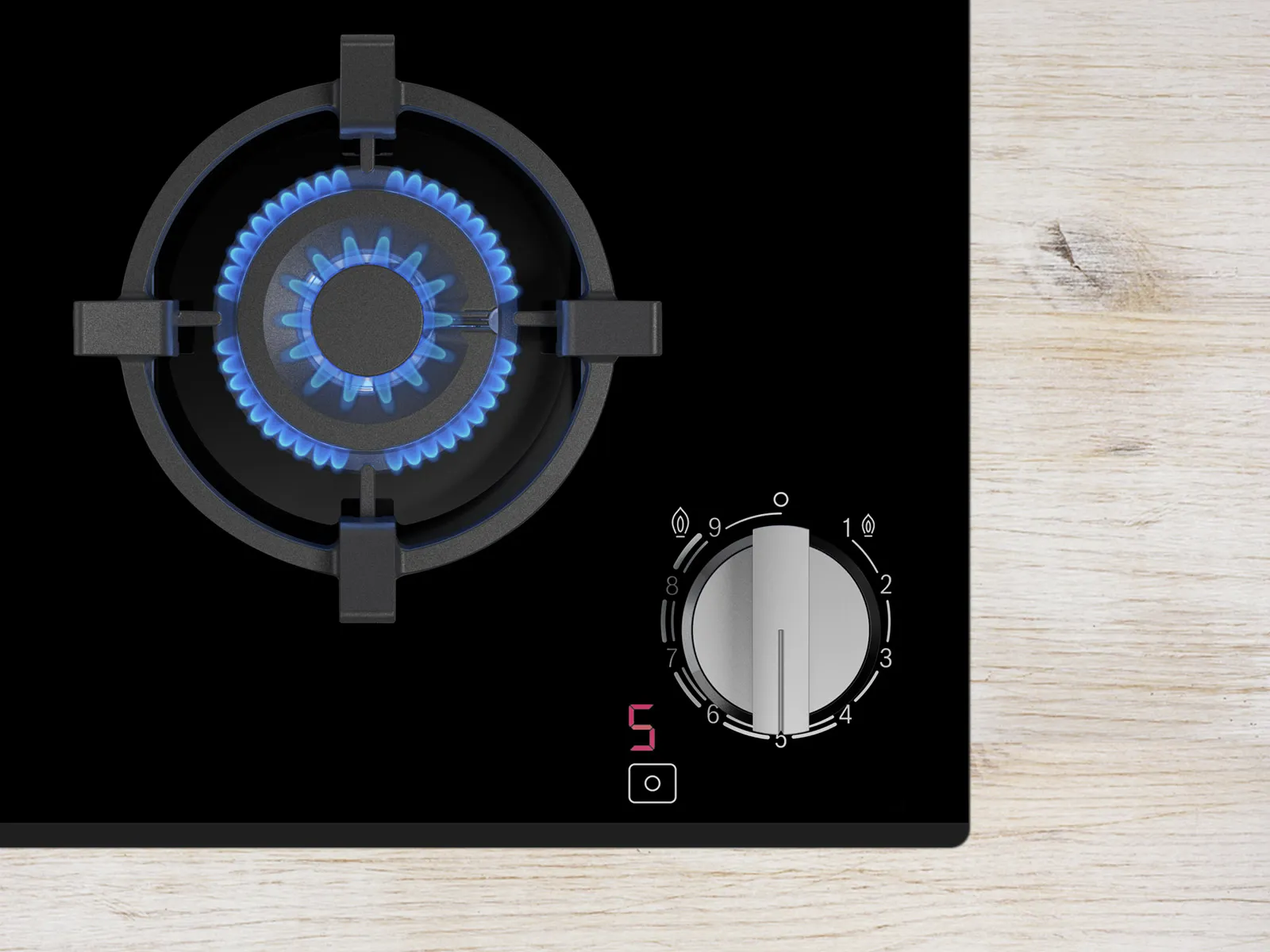 Top view of a gas stove burner with blue flame and control knob, set to level 5, on a sleek black surface.
