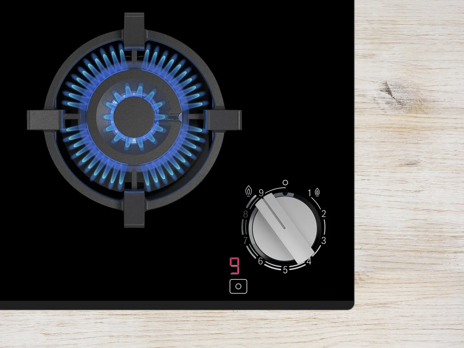 Close-up of a gas stove burner with blue flames, and a control knob displaying settings on a sleek black surface.