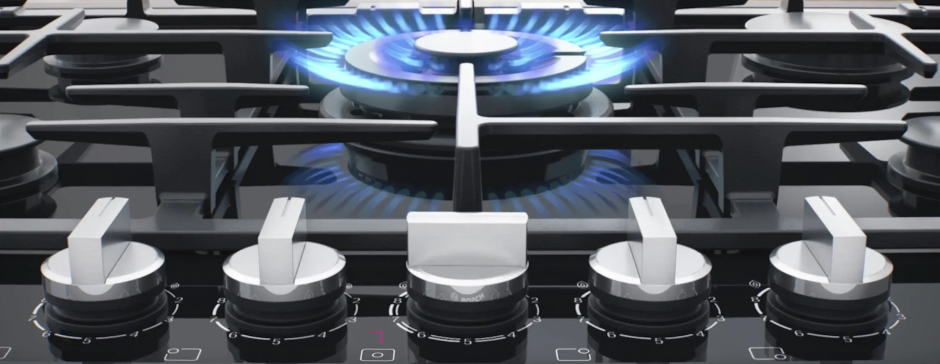 Gas stove burners with blue flames, modern kitchen appliance design.