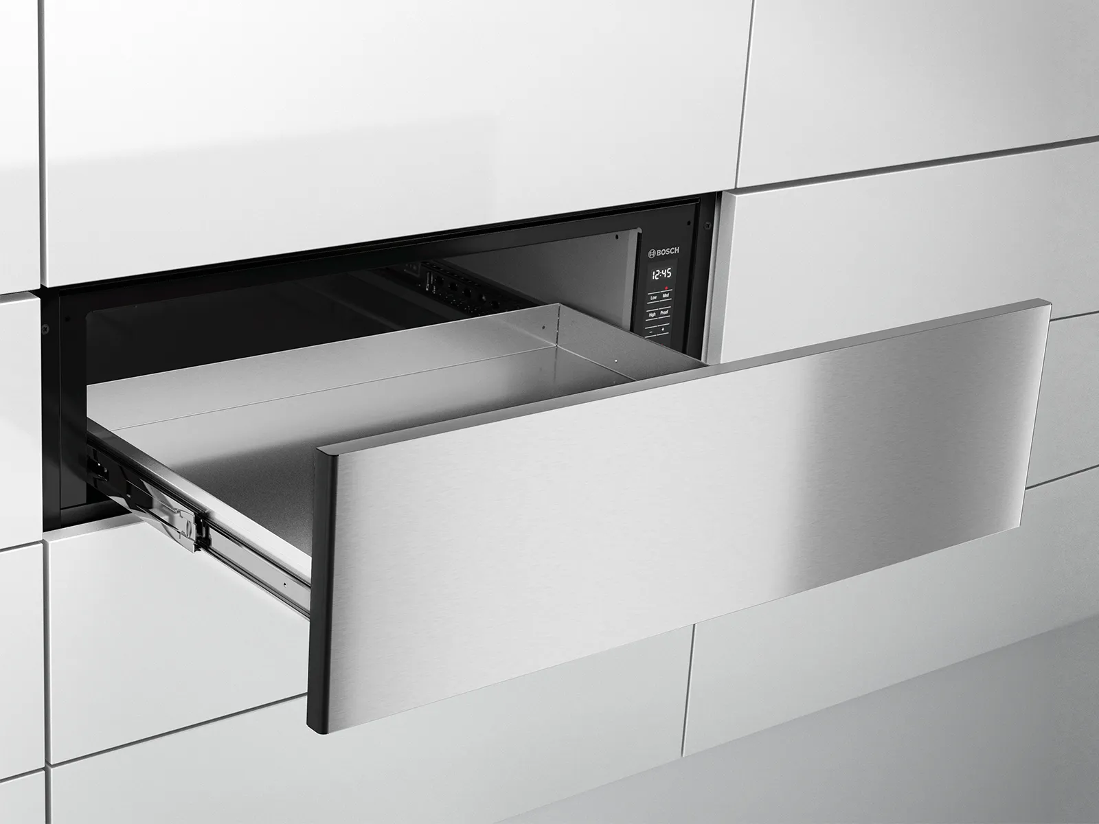Sleek, built-in Bosch warming drawer in stainless steel, partially opened within a modern, handle-less kitchen cabinetry setup