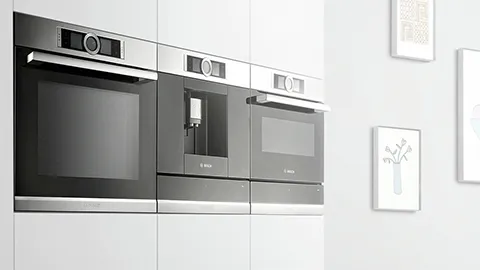 Moderne innbyggingsovner i minimalistisk kjøkkeninnredning.