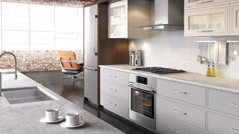 Cuisine moderne avec armoires blanches, électroménagers en acier inoxydable, îlot en marbre avec deux tasses et fauteuil près d’une grande fenêtre.