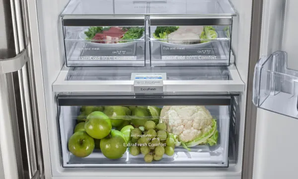 Frigorífico combinado Bosch ExtraFresh Confort em aço inoxidável, com ecrã digital, integrado numa cozinha moderna e luminosa.