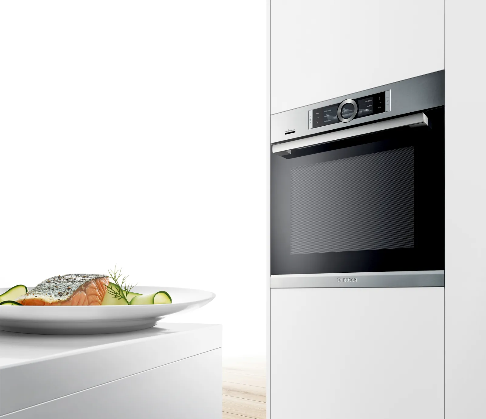 Bosch built-in oven in modern kitchen setup alongside a salmon dish on the countertop.