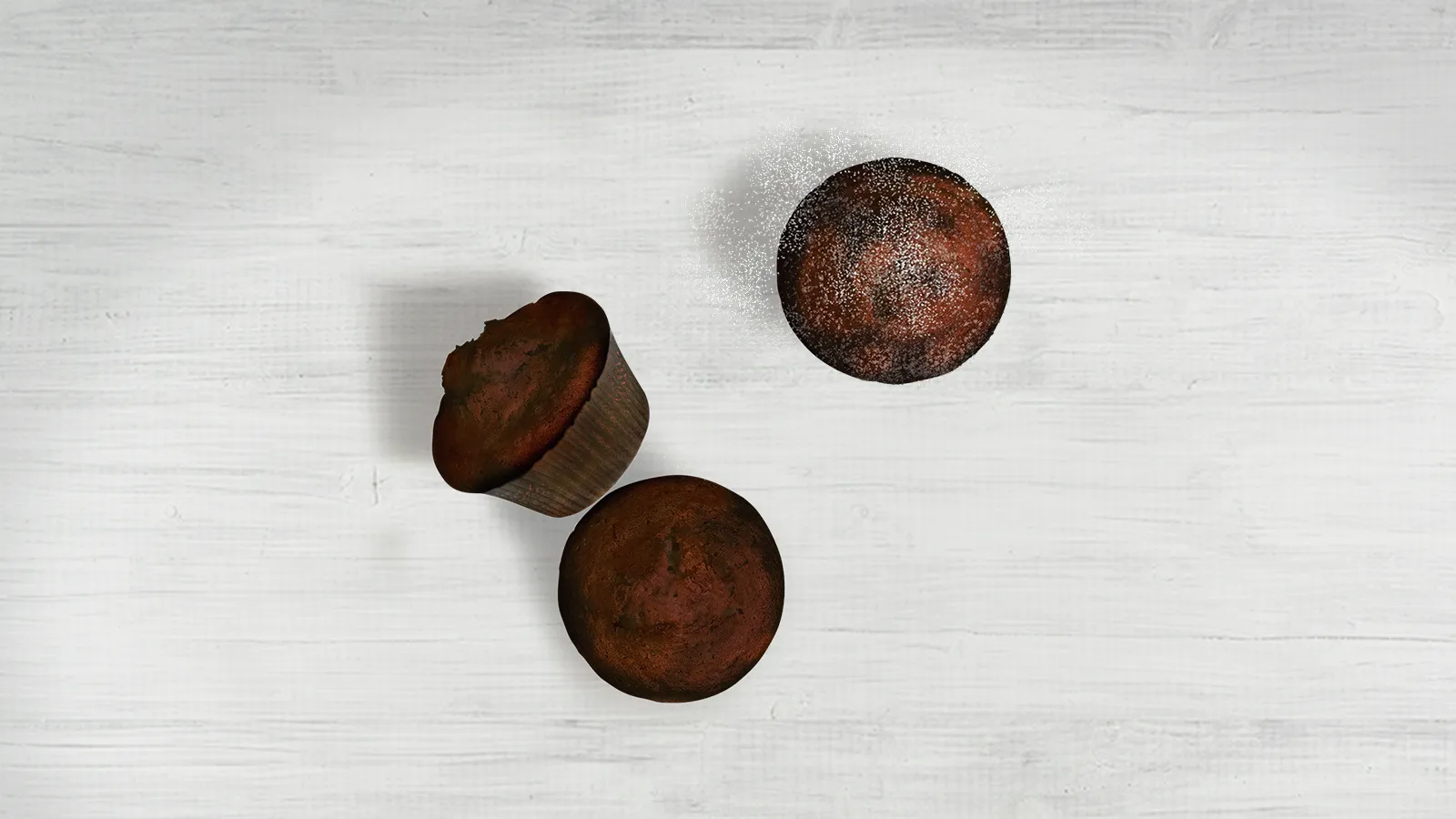Three dark brown mushroom caps on a light wooden surface.
