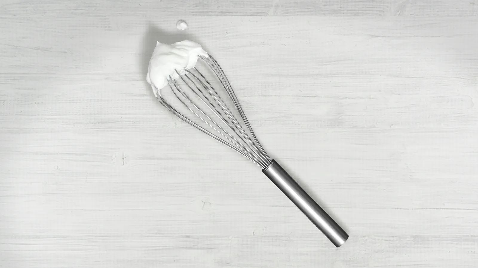 Whisk kitchen utensil on a light wooden background.