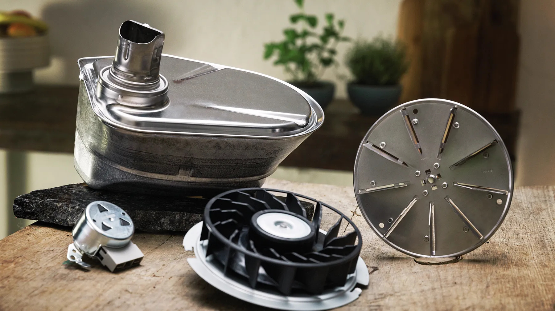 Küchengeräteteile - Mixer, Ventilator und andere Komponenten auf einer Holzoberfläche.