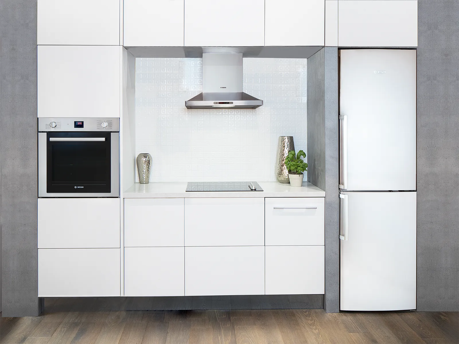 White compact modern kitchen with Bosch wall oven, induction cooktop, and refrigerator