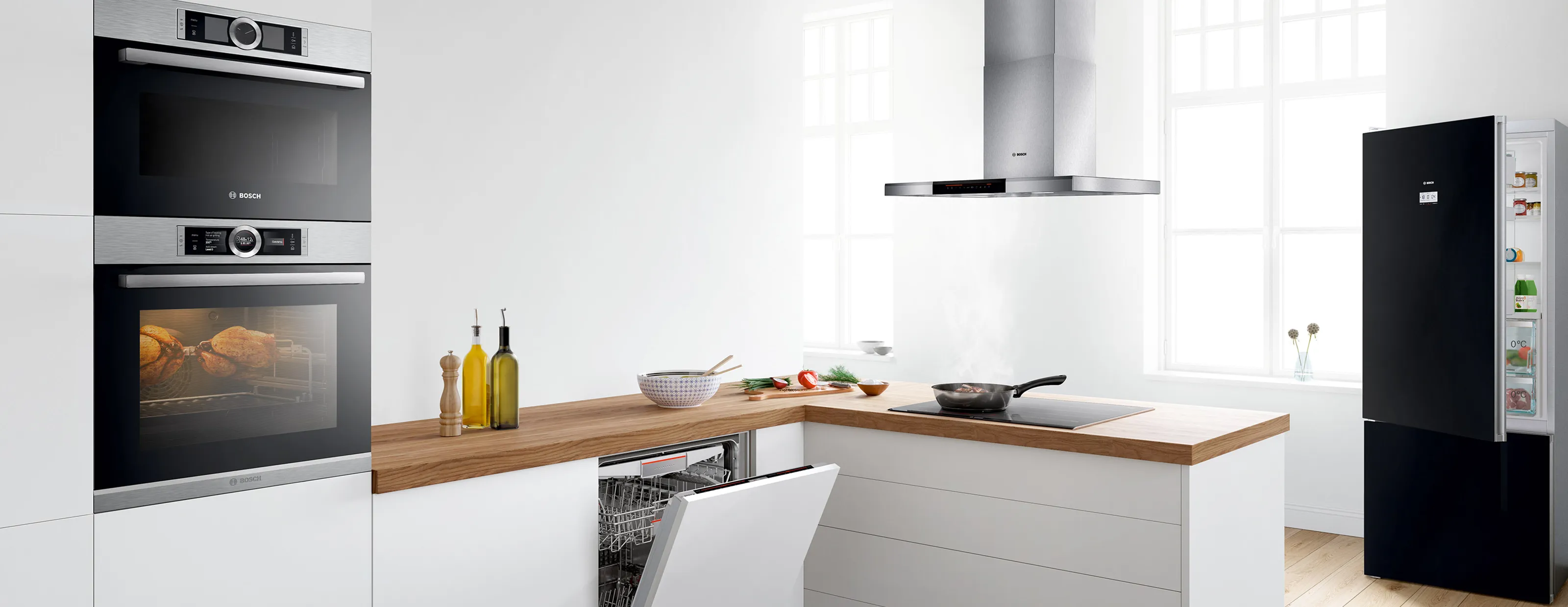 Modern kitchen with white cabinets, wooden countertop, built-in oven, and appliances.