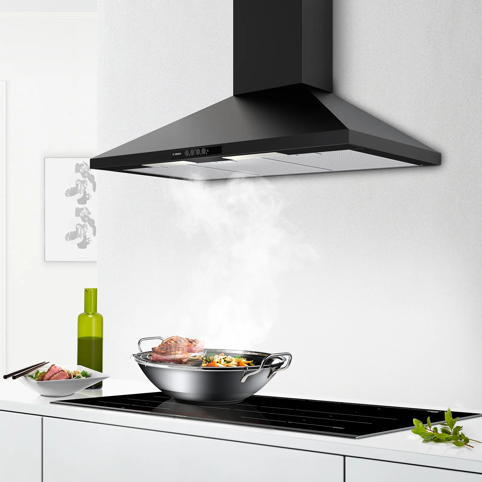 Pan cooking on an induction hob with cooker hood taking away steam