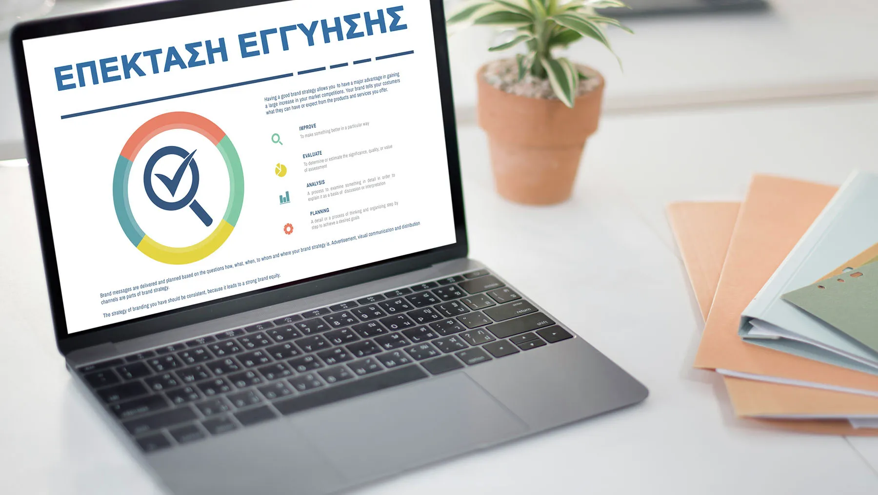 alt-Φορητός υπολογιστής displayΕφαρμογή" (Ελληνική για " Επέκταση Εγγύησης") στην οθόνη, περιτριγυρισμένη από προμήθειες γραφείου.