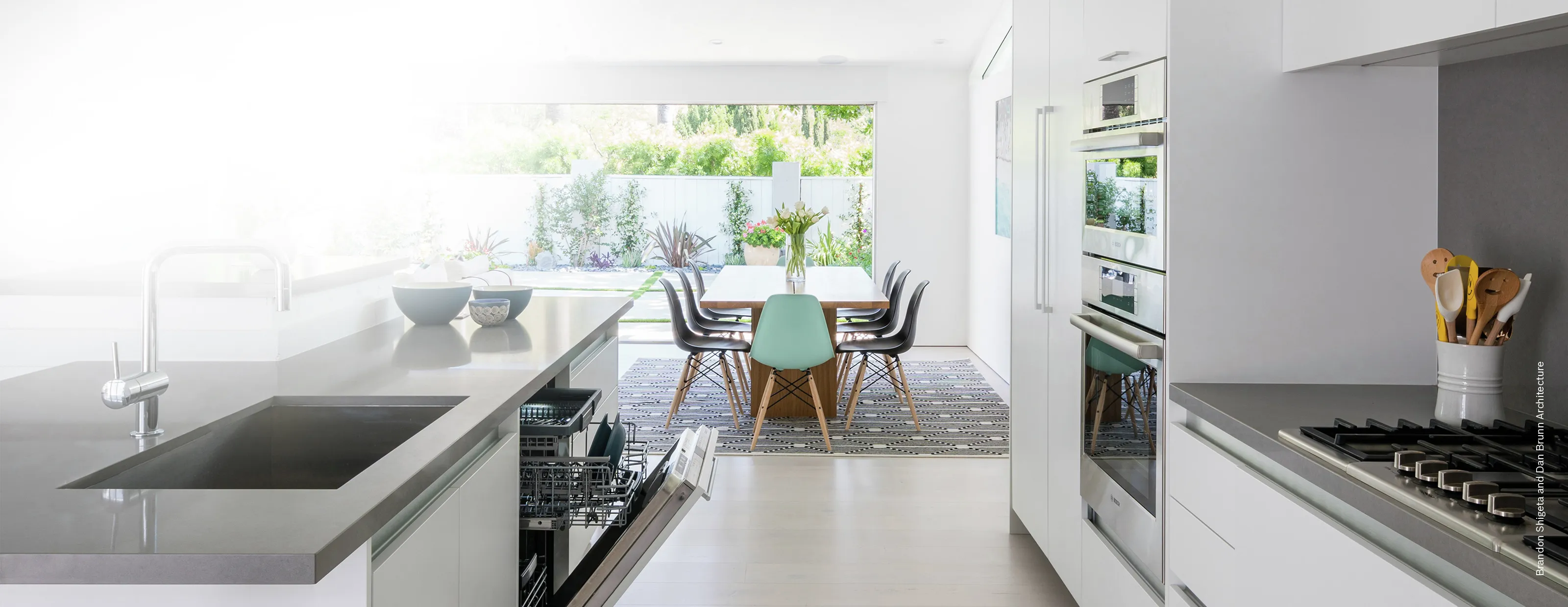 Modern kitchen with Bosch built-in appliances, a sleek countertop, and a dining area with garden view.