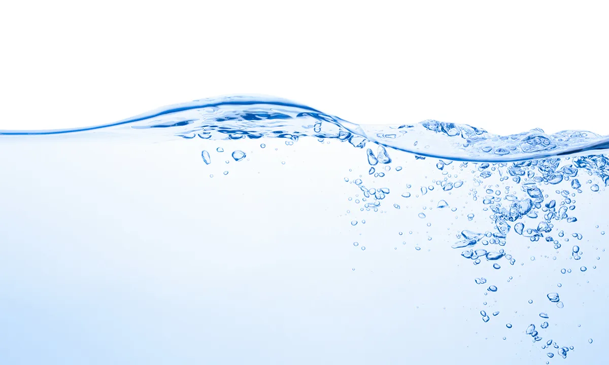 Close-up of clear water surface with bubbles, creating a wavy pattern against a white background.