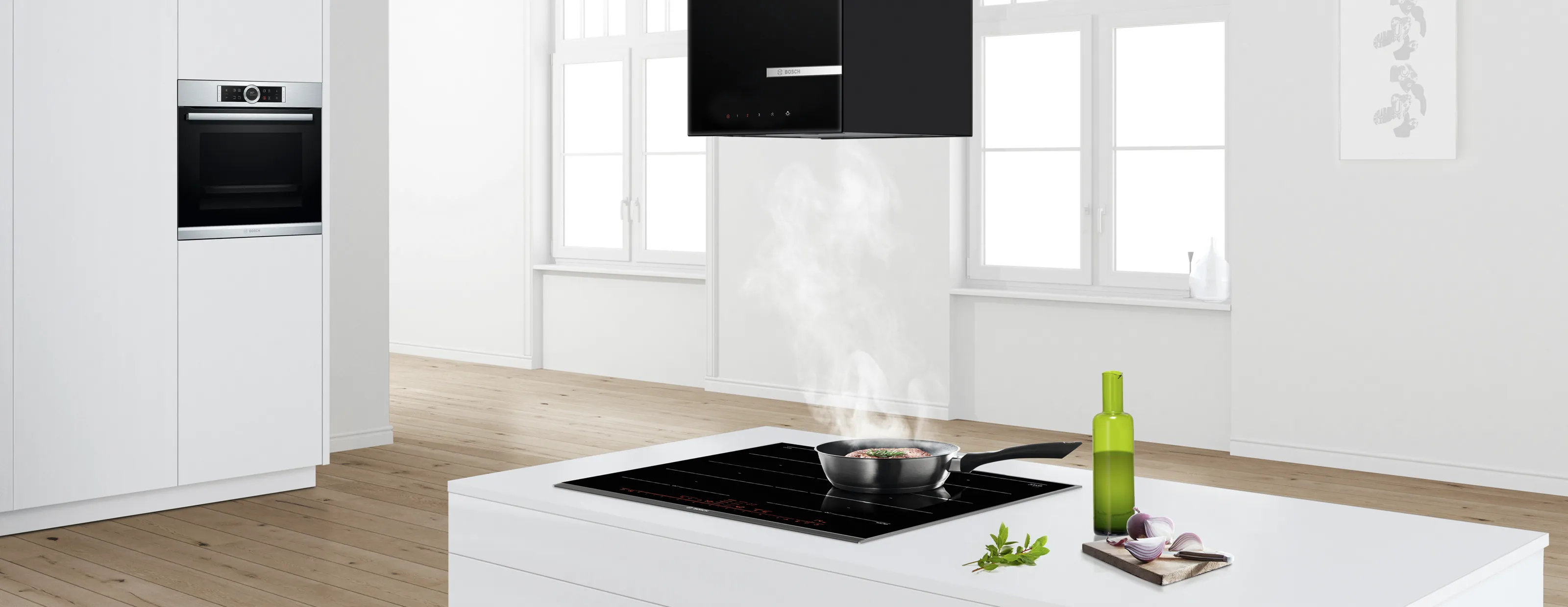 מחבת עם פחמימות מבושלות מעלה אדים על כיריים חשמליות, עם תנור מוברש מאחור, ומיכלי תיבול ליד חלון.