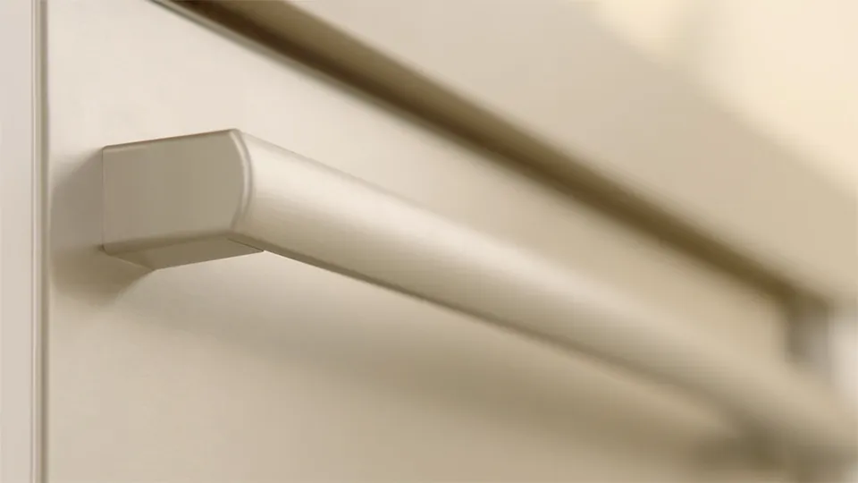 Close-up of a Bosch sleek metal kitchen cabinet handle on a light-colored surface.