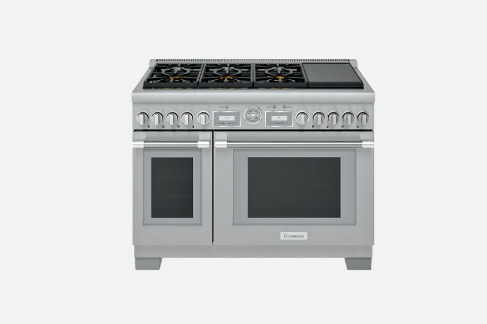 alt-Stainless steel professional gas range with multiple burners and ovens.