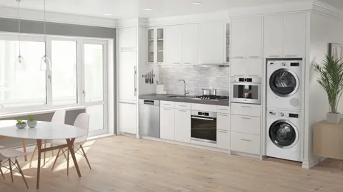 Modern kitchen with white cabinets, Bosch built-in appliances, and a dining area by large windows.