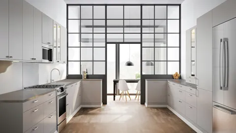 Modern kitchen with white cabinets, Bosch stainless steel appliances, and large windows providing natural light.