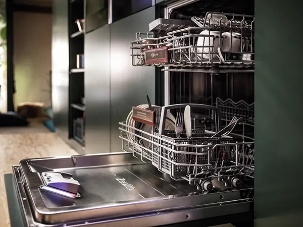 Lavastoviglie aperta con stoviglie pulite all’interno, in un ambiente cucina.