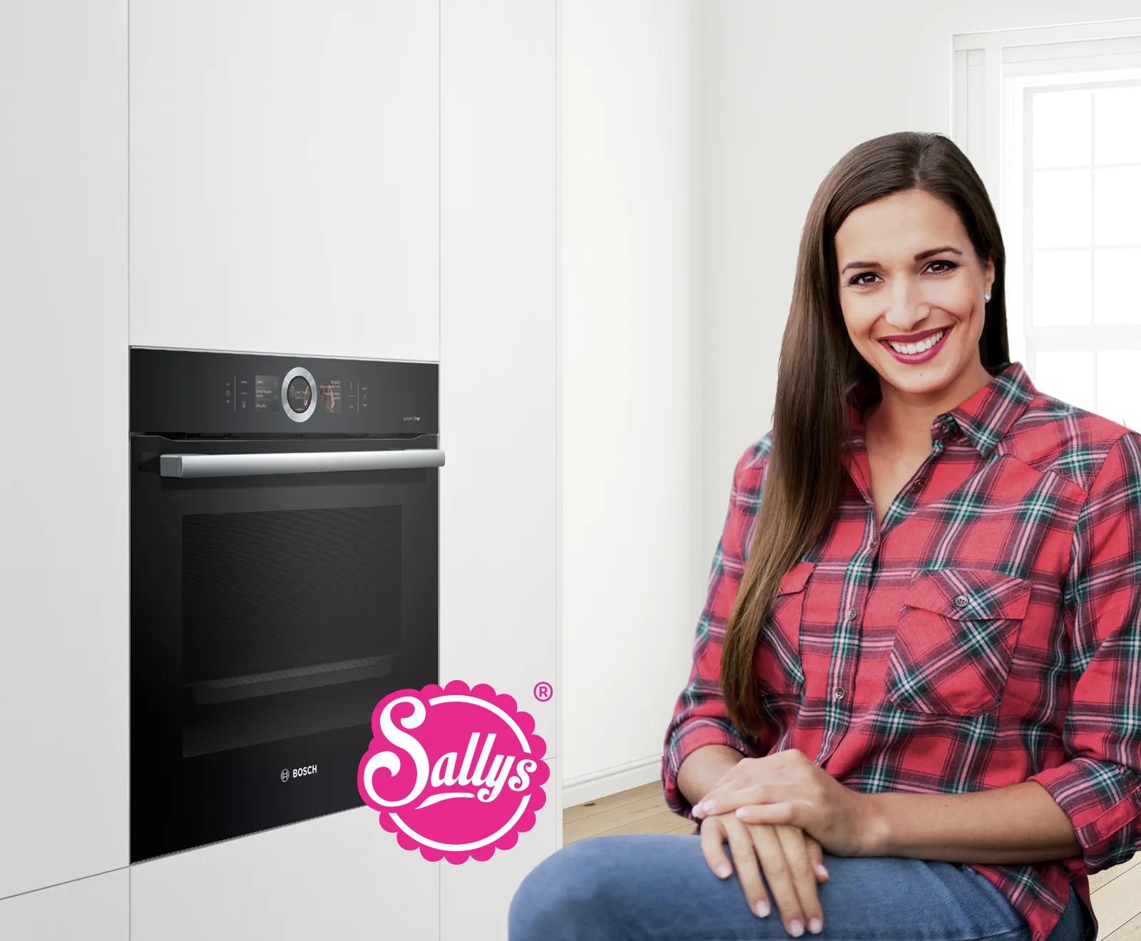 Die Food-Bloggerrin Sally sitzt lächelnd in einer hellen Küche neben einem in die weiße Wand eingebauten, schwarzen Bosch-Backofen.