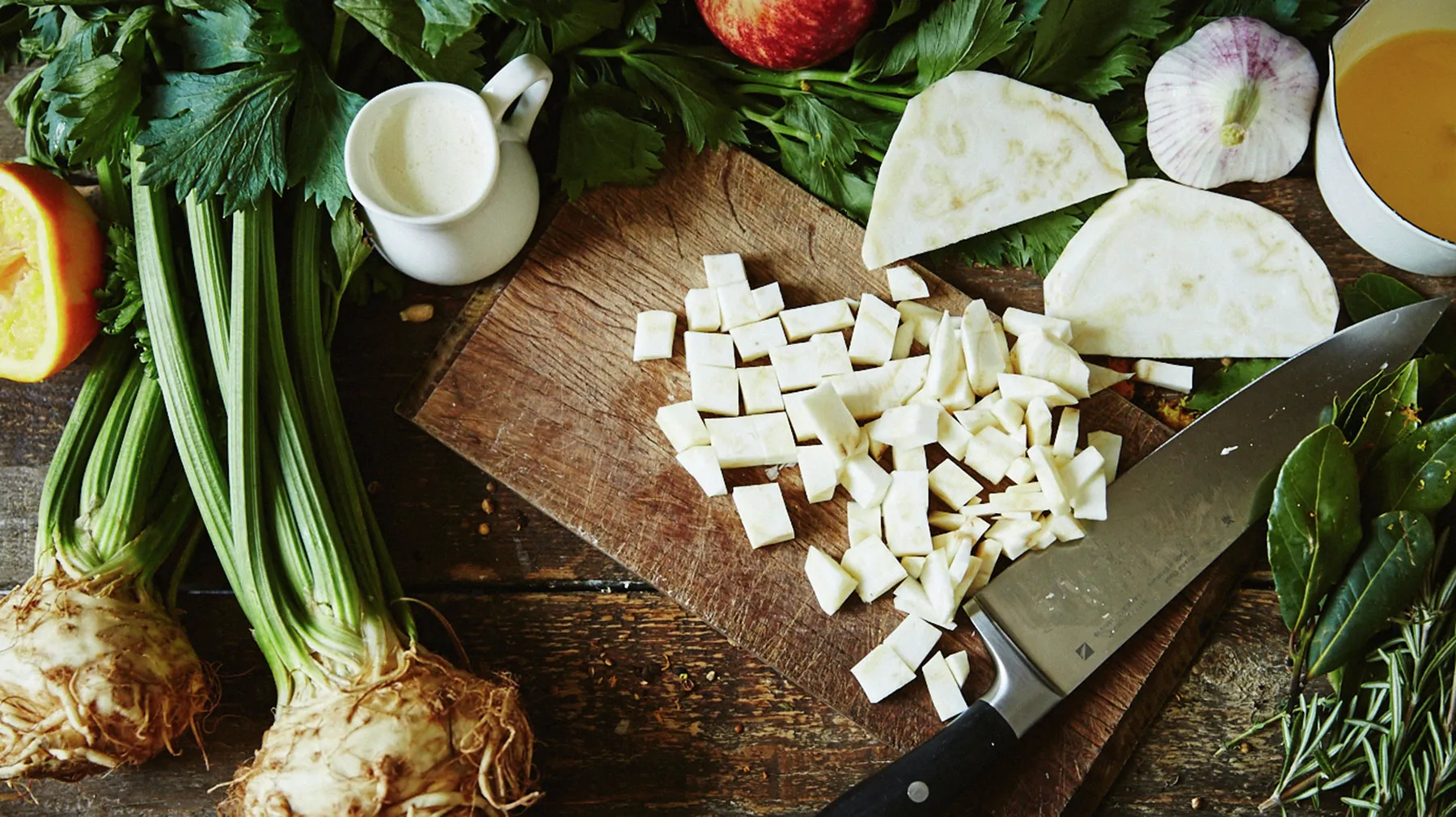 Assortment of fresh vegetables, herbs, and dairy products on a wooden cutting board.