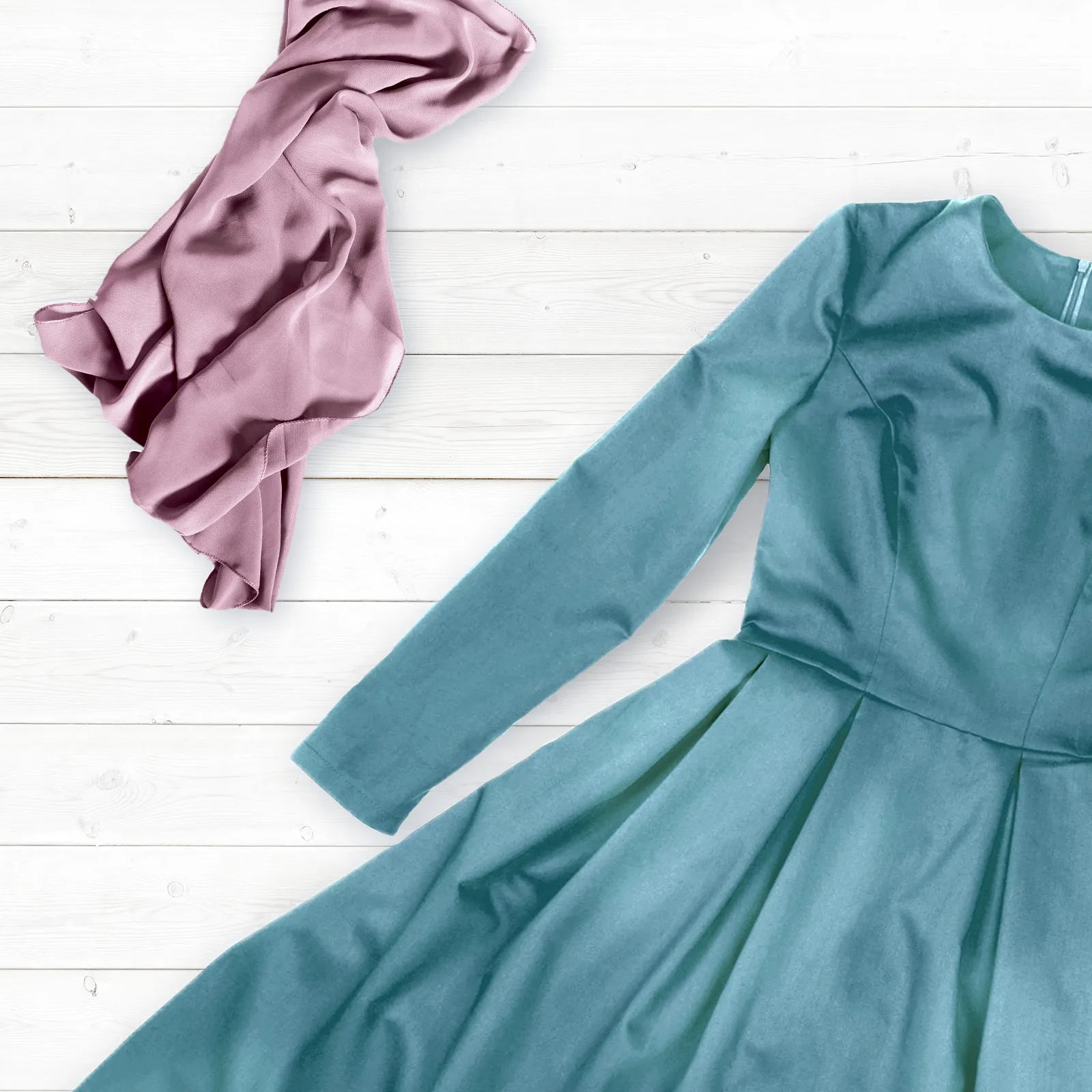 Rochie teal şi eşarfă roz pe fundal alb din lemn.