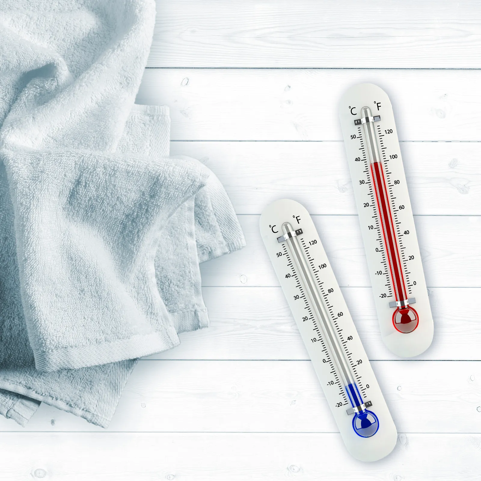 Termometre, prosop şi suprafaţă de lemn indicând măsurarea temperaturii.
