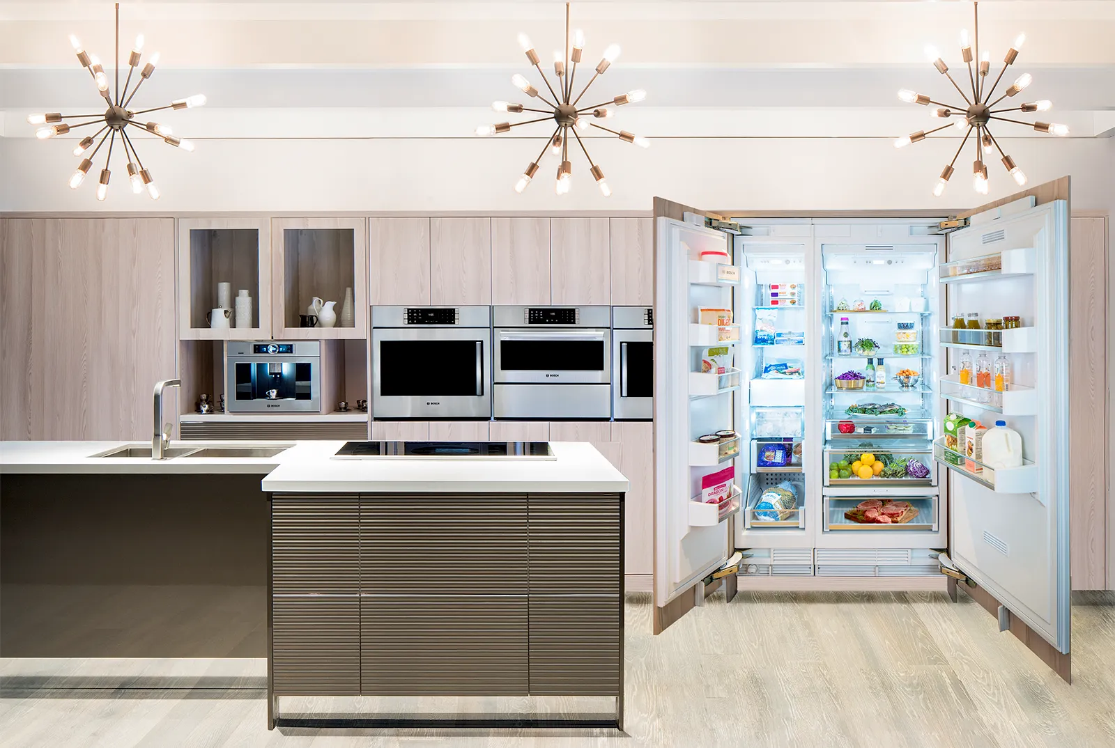 Modern kitchen with an open Bosch Single Door Refrigerator & Freezer Columns full of food items and sleek Bosch appliances.