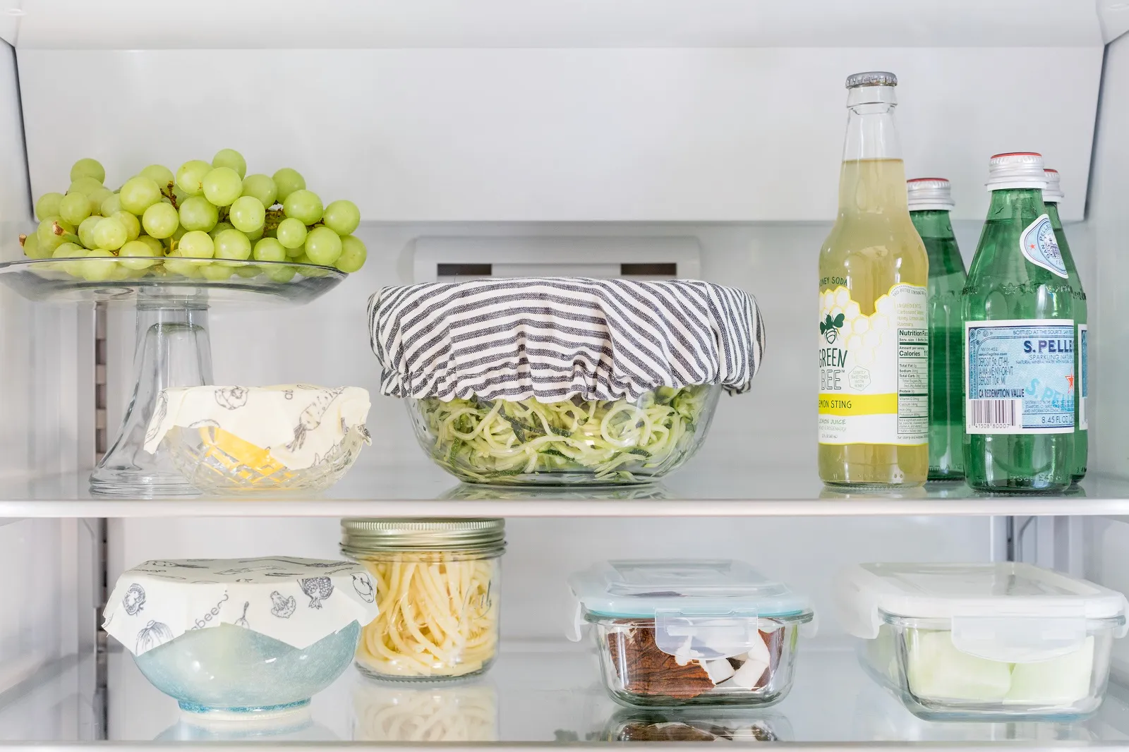 Bosch Refrigerator with assorted foods and beverages, including grapes, salad, and bottled drinks.