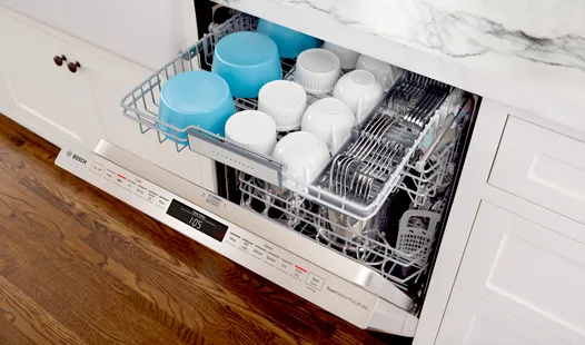 Bosch dishwasher with open upper rack showing clean dishes and bowls.