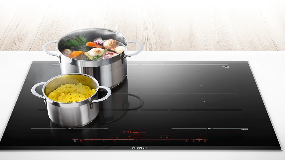 Pans with food cooking on induction hobs