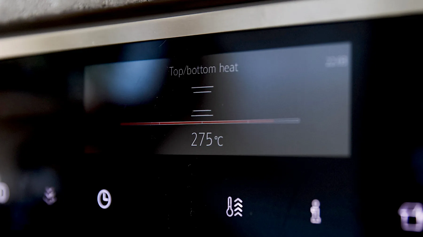 Display eines Backofens mit der Anzeige 'Top/bottom heat' und '275°C' sowie Symbolen für Uhr, Heizart und weitere Funktionen.