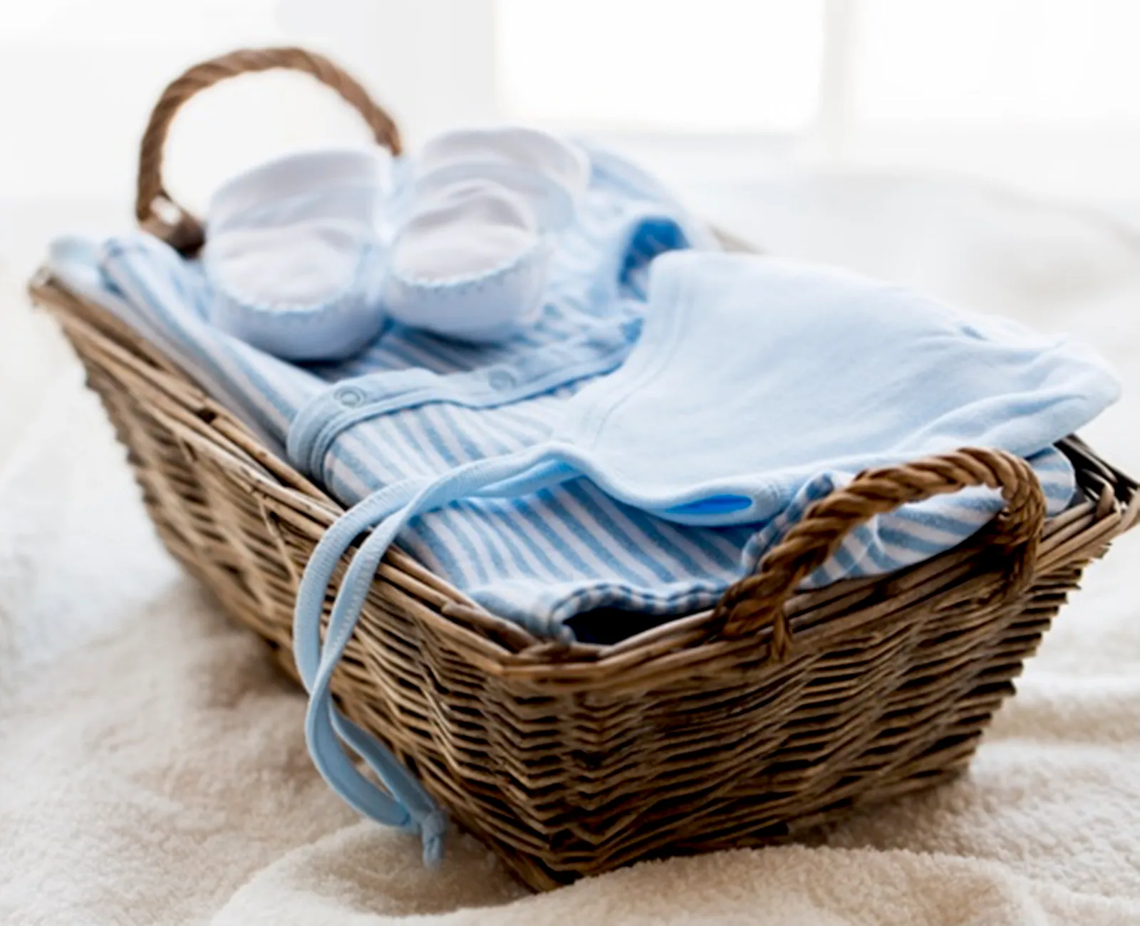 Clean baby clothes in a laundry basket