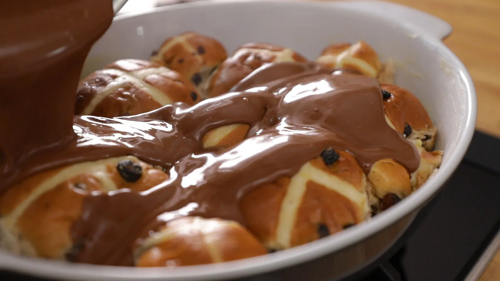 Pouring chocolate over hot cross buns