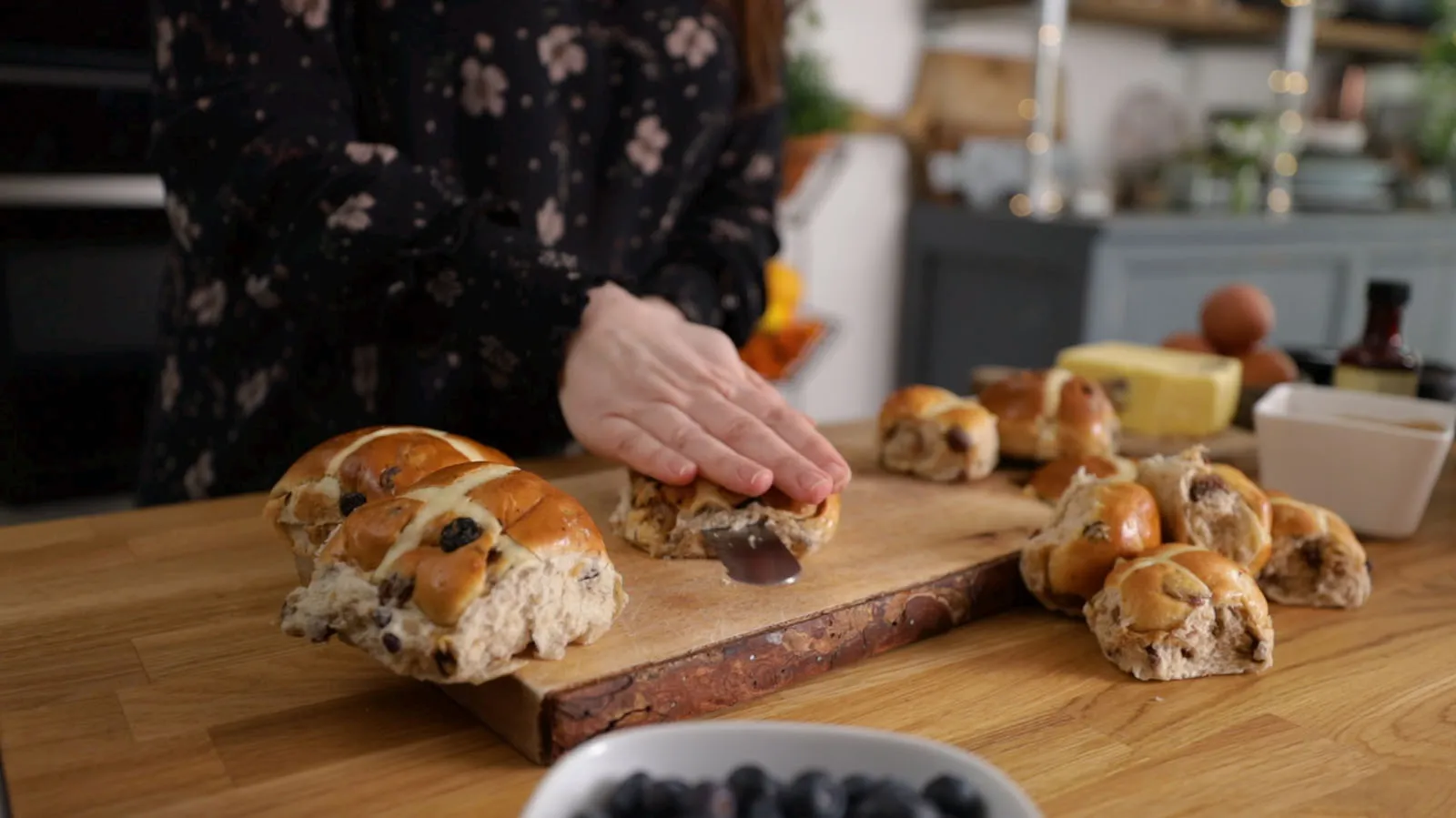 Person slicing hot cross buns in half