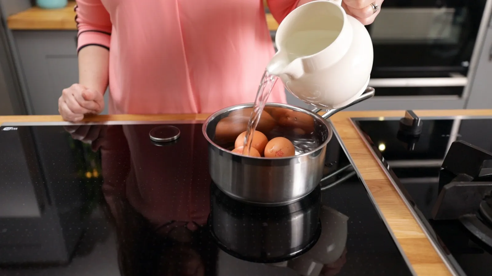 Person pouring water over eggs