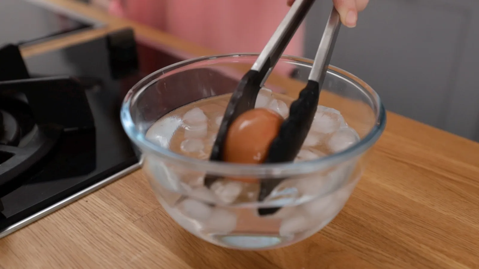 Person putting eggs in ice water