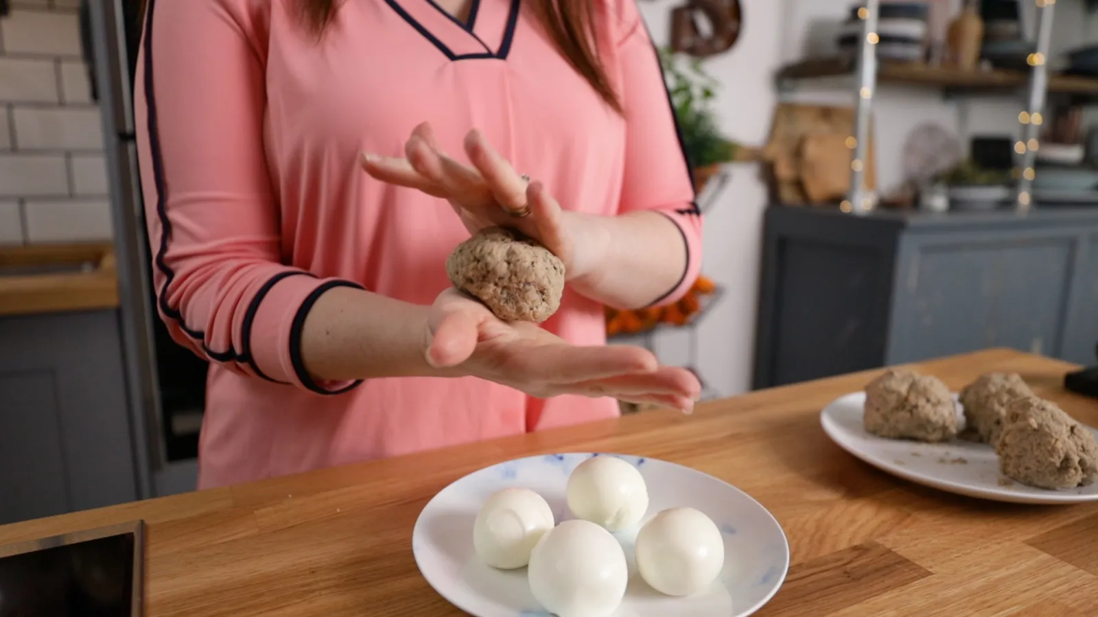 Person rolling sausagemeat around boiled egg