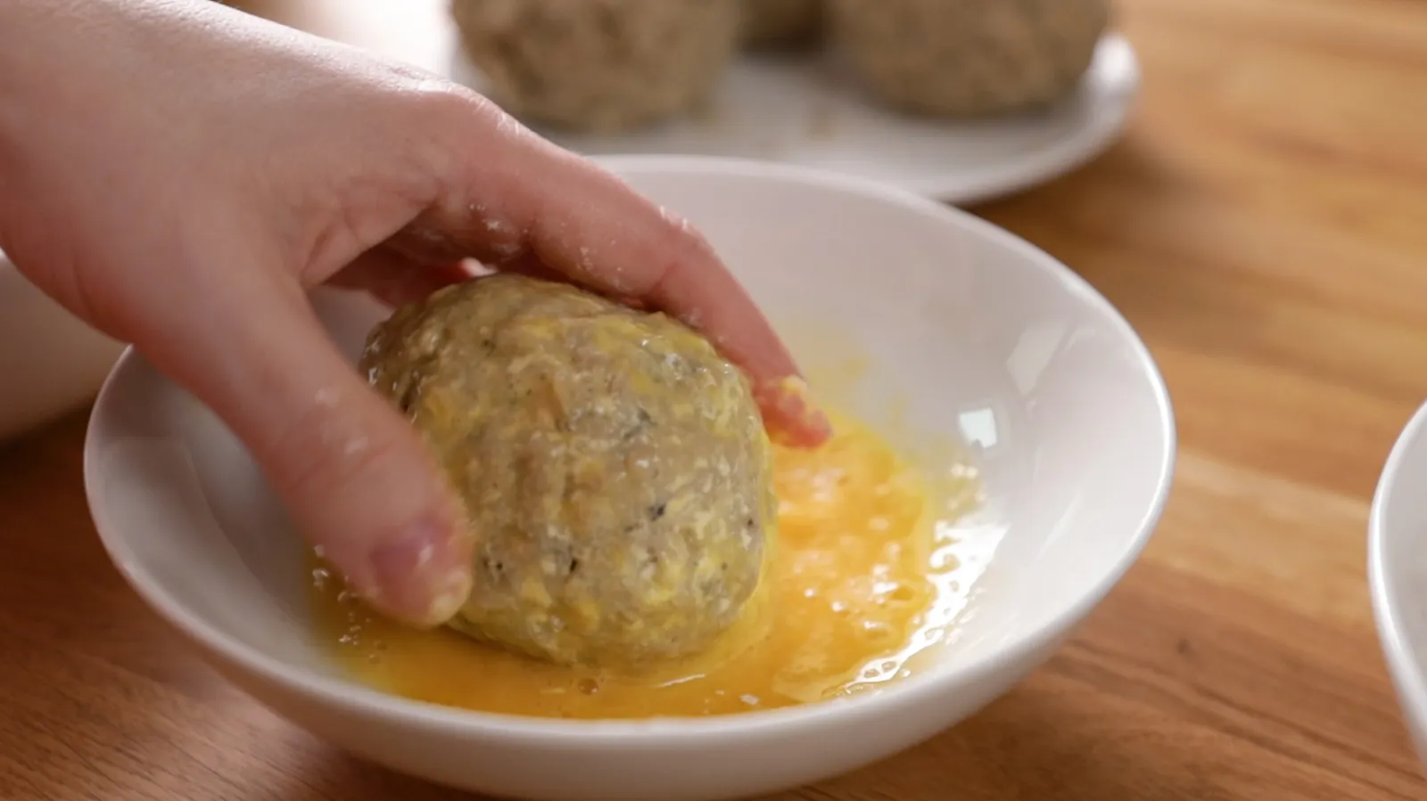 Rolling the egg in breadcrumbs