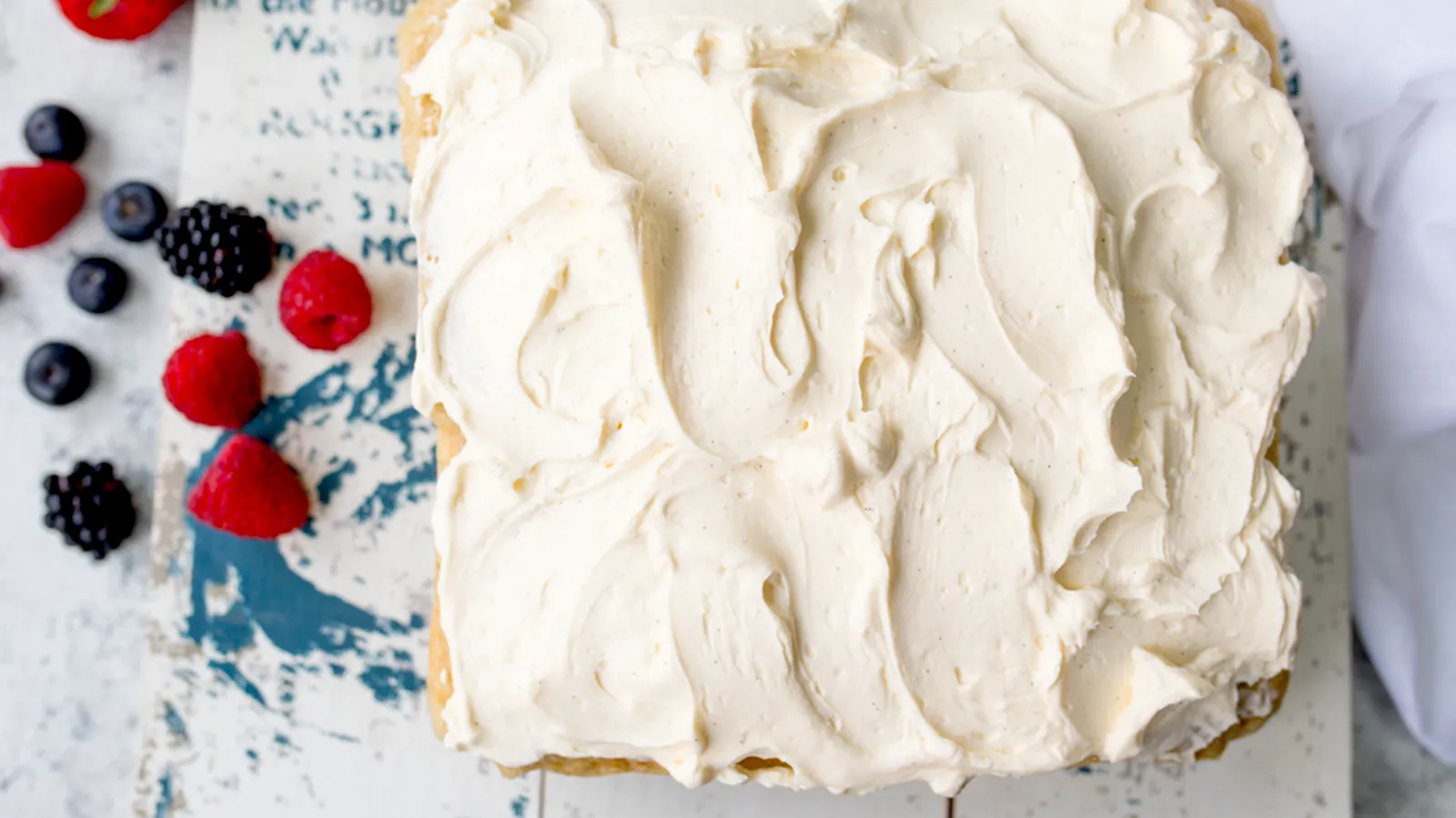 cake with icing and berries next to it
