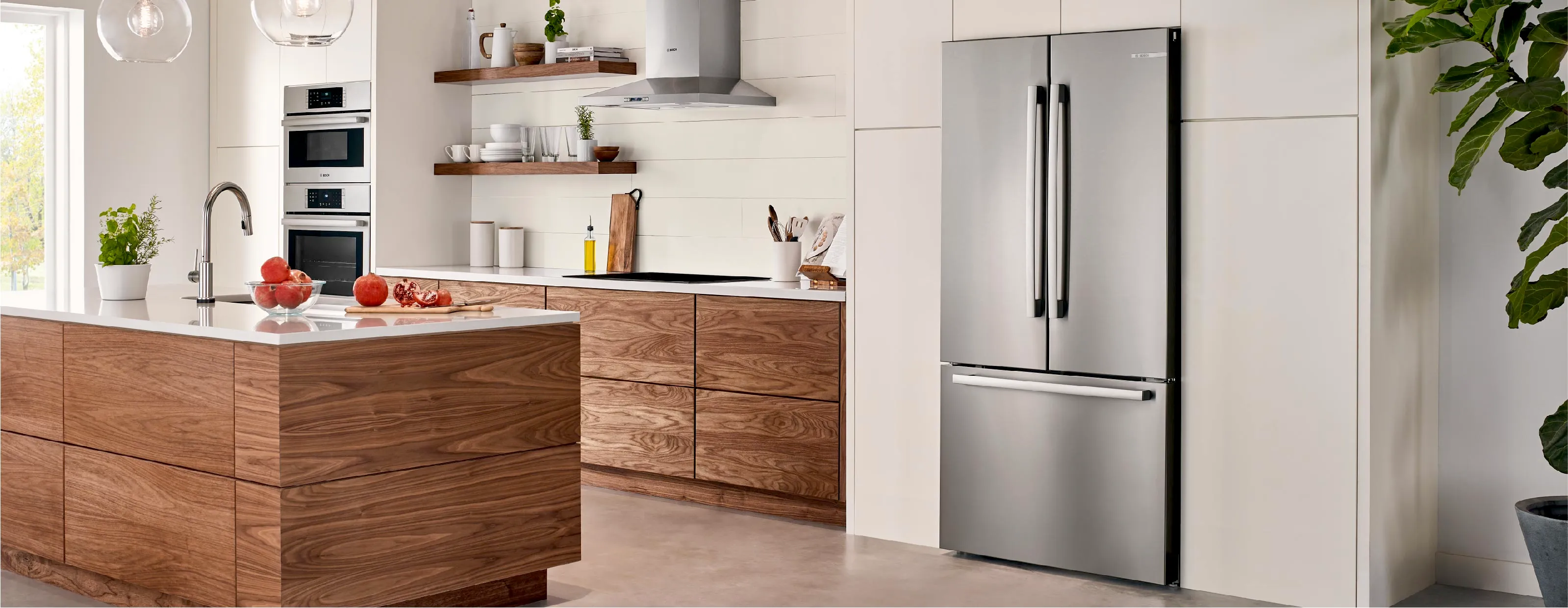 Modern kitchen with Bosch stainless steel fridge and wooden cabinets, featuring an island and oven.